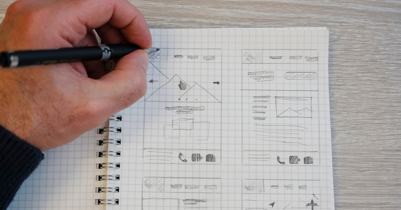 Designer sketching wireframes and prototypes on paper