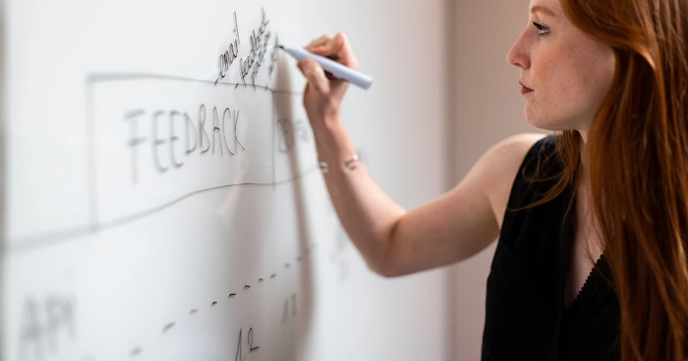 UX researcher mapping customer feedback on a whiteboard